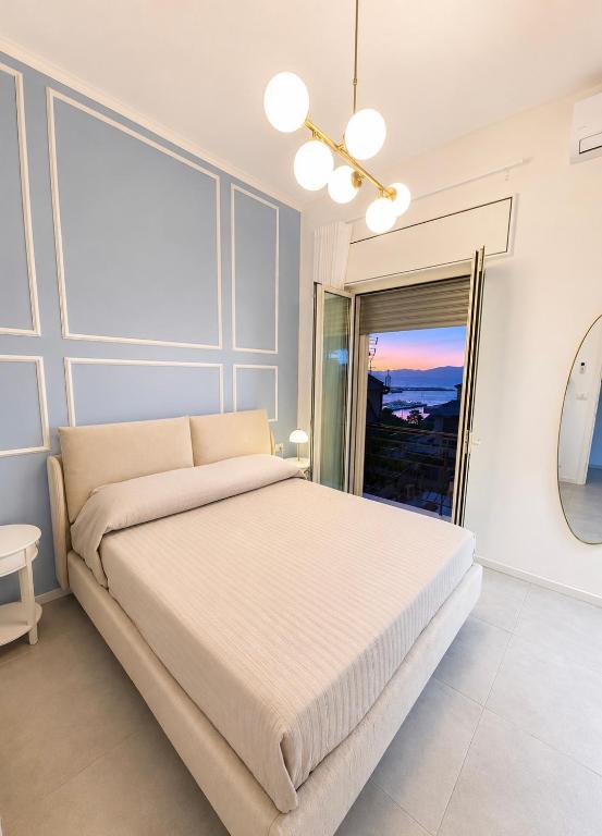 a white bedroom with a large bed and a window at Rachele Boutique Apartments in Agropoli