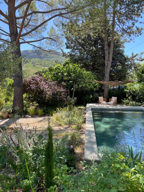 a swimming pool in a garden with trees and plants at Maison Caramel in Condorcet