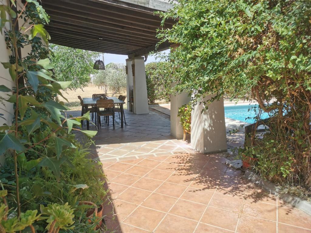 a patio with a table and chairs under a pergola at Casa los Jinetes in Carmona