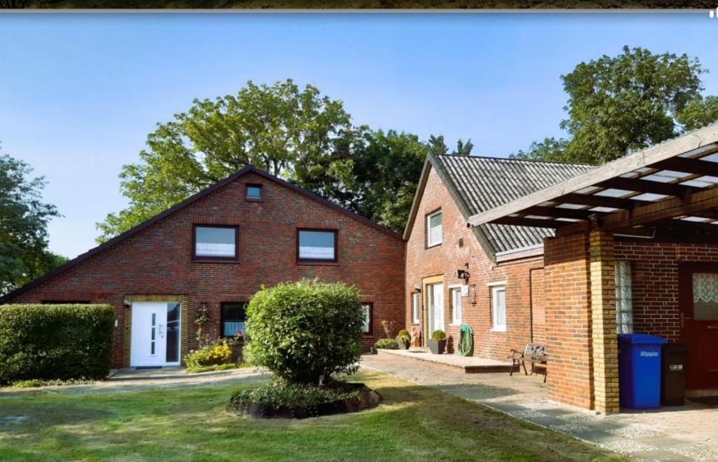 a brick house with a roof at Ferienwohnung "Pfoten & Komfort" in Butjadingen