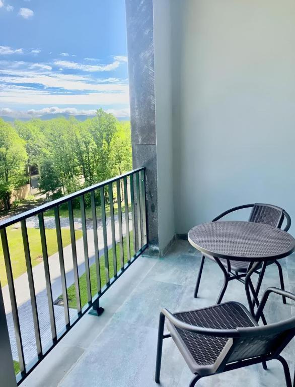 a balcony with two chairs and a table and a view at Forest view Tsaghkadzor in Tsaghkadzor