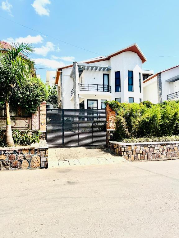 a house with a black fence in front of a driveway at KiGALI NORMAL VIEW APARTMENT in Kigali