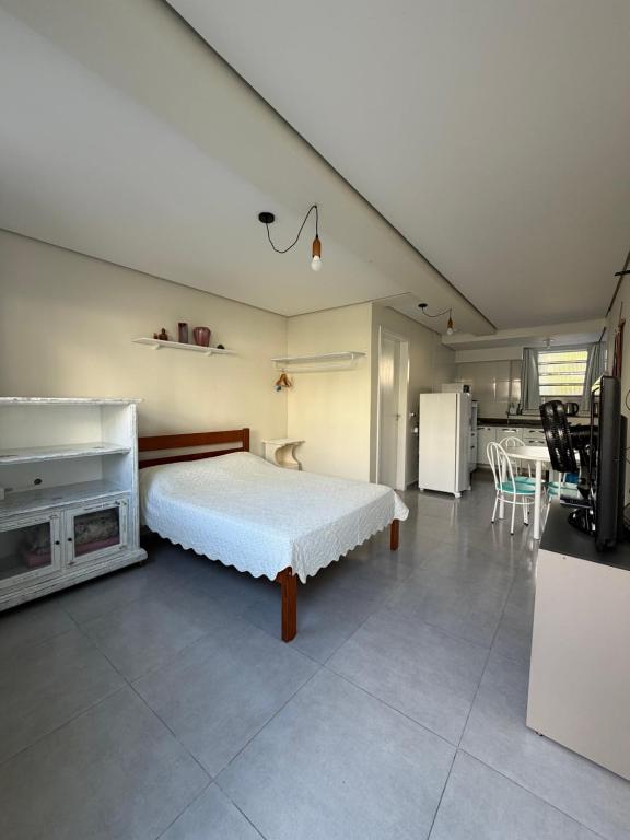a bedroom with a bed and a kitchen with a table at Espaço inteiro e tranquilo in São José
