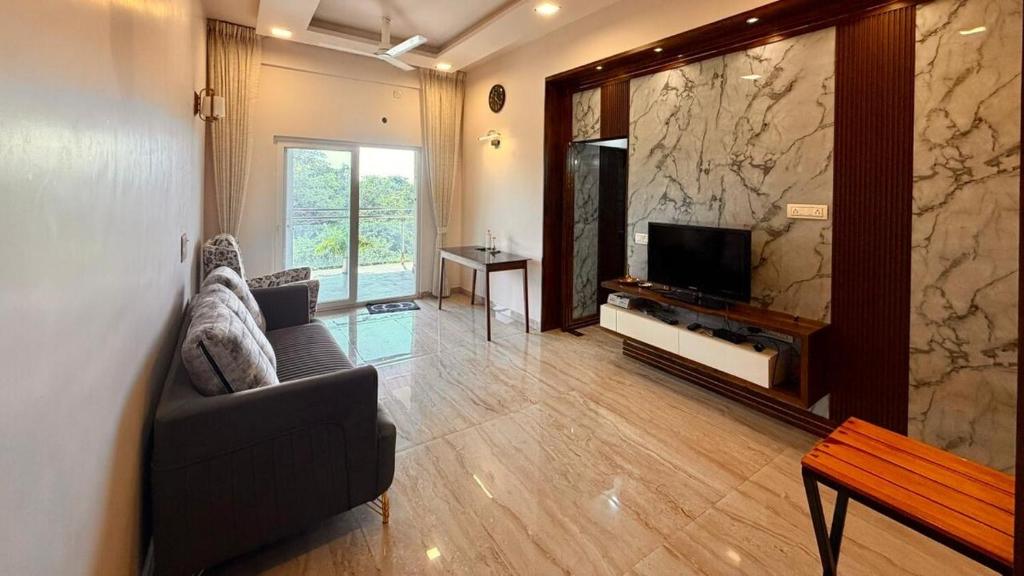 a living room with a couch and a television at Neelaashray Sea view apartment in Ratnagiri