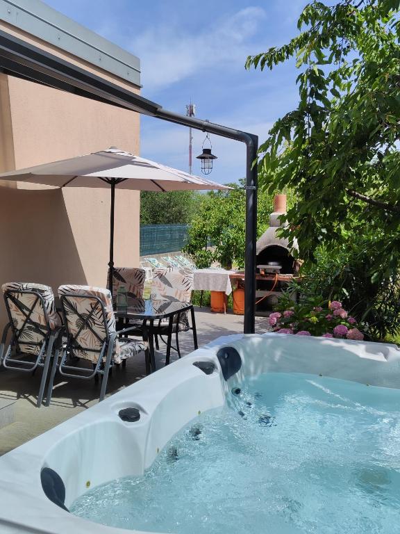 a hot tub on a patio with a table and chairs at Rooms Katarina in Poreč