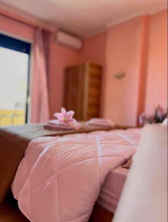 a pink bed with a pink flower on top of it at Room 357 in Tirana