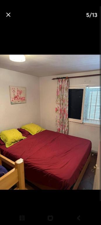 a bedroom with a red bed with yellow sheets and a window at ,1 habitacion in Esplugues de Llobregat