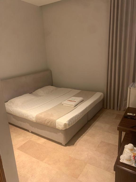 a small bedroom with a bed in a room at Hotel room in Salalah