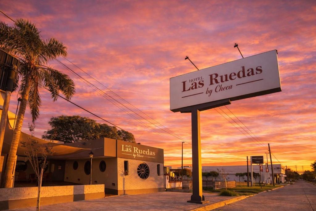 a sign for a la ruedas restaurant with a sunset at Hotel las ruedas by Choca in Arroyito