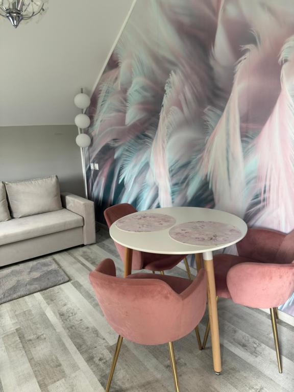 a table and chairs in a living room with a wall at Apartament nad jeziorem in Lubkowo