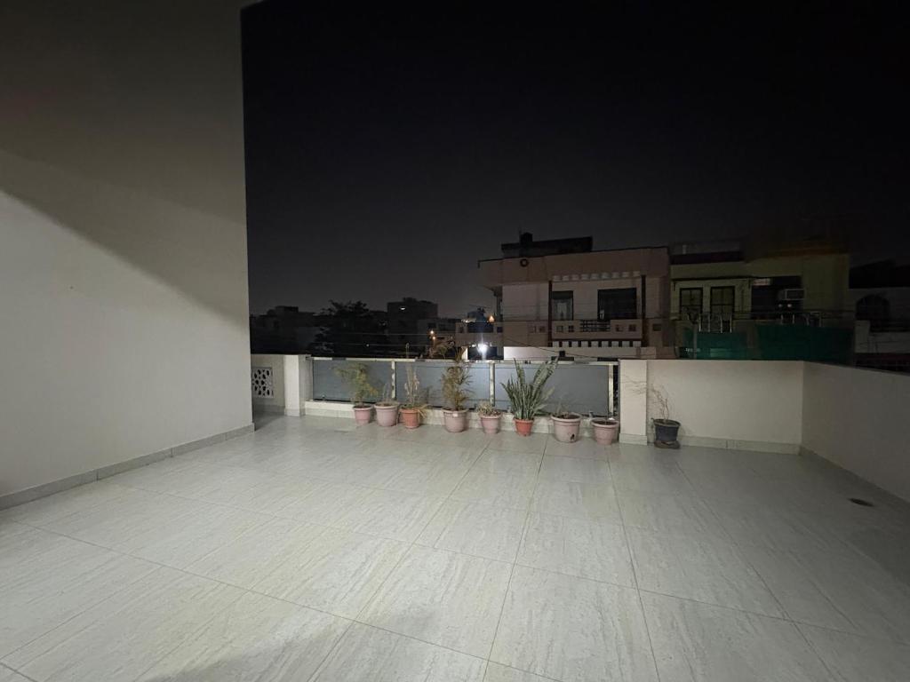 an empty room with potted plants on a balcony at night at Entire 2Bhk Flat with a big Balcony in Jaipur