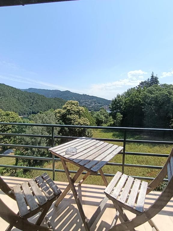 a picnic table and two chairs on a balcony at Residencial Do Rita em Rio Caldo in Geres