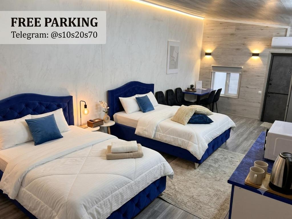 a hotel room with two beds and a table at 24 drop 7 Night Check-In Hotel in Chişinău