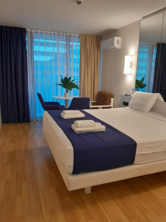 a bedroom with a large bed with towels on it at ა ბლოკი in Stantsiya Batumi-Passazhirskaya