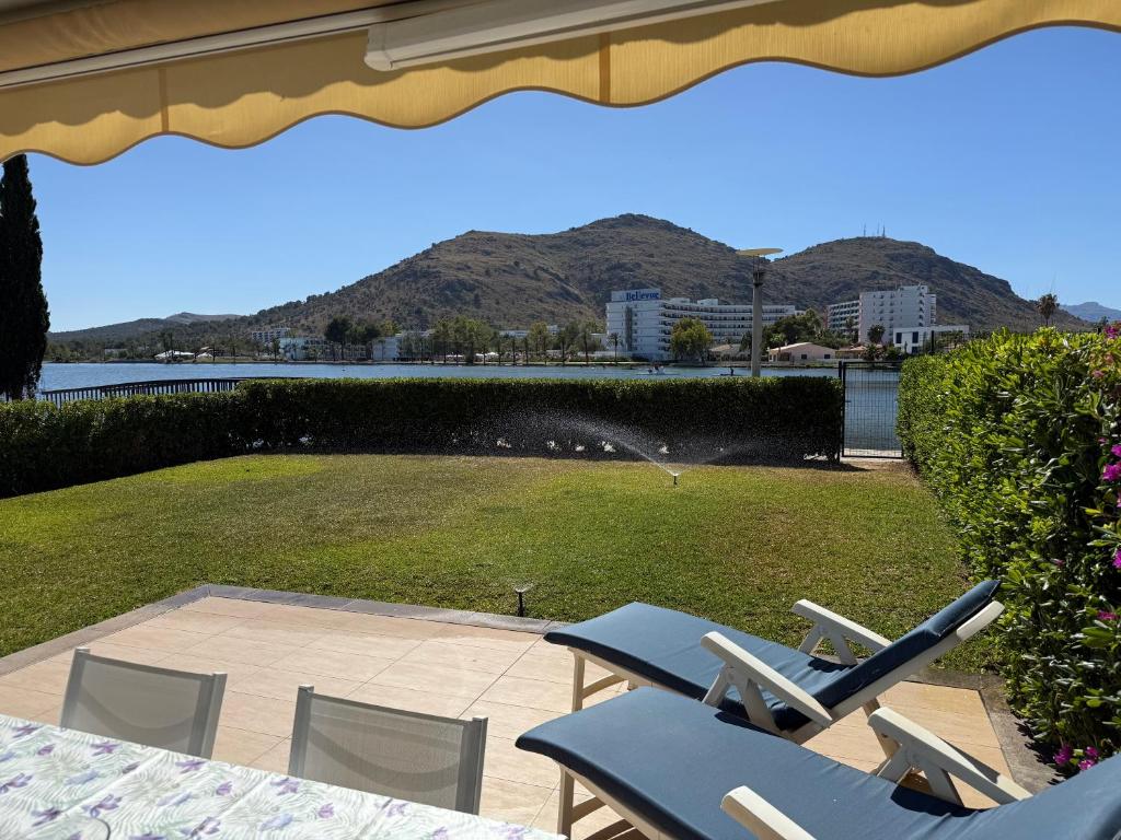 a group of chairs sitting on a patio next to a lawn at Villa Dulce in Port d'Alcudia