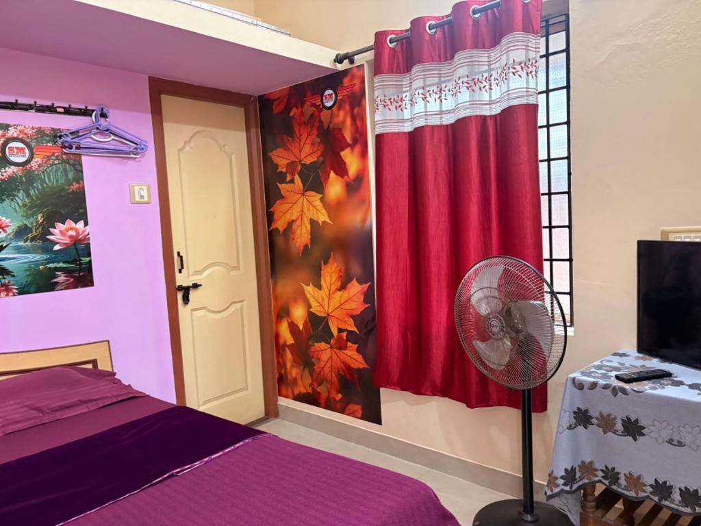 a bedroom with a purple room with a fan at SM Guest Room in Mangalore
