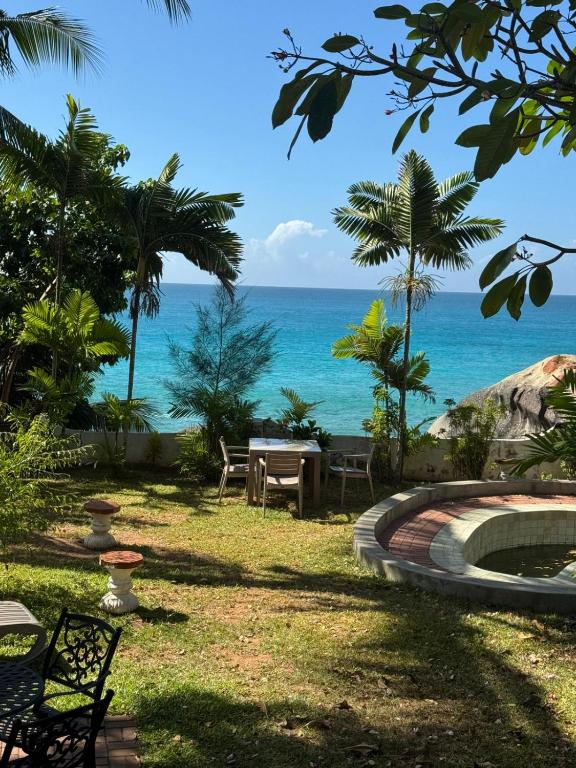 a view of the ocean from a resort yard at Le Rocher De Machabee in Mahe