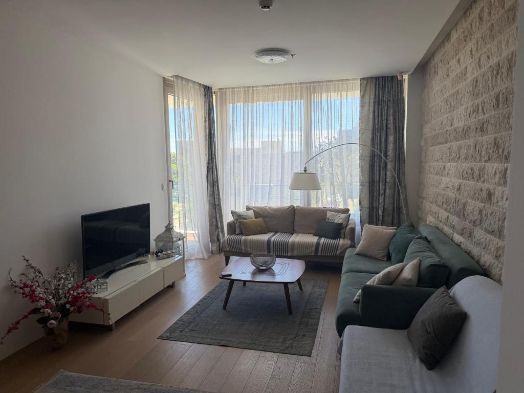 a living room with a couch and a tv at Dukley residence Lux in Budva