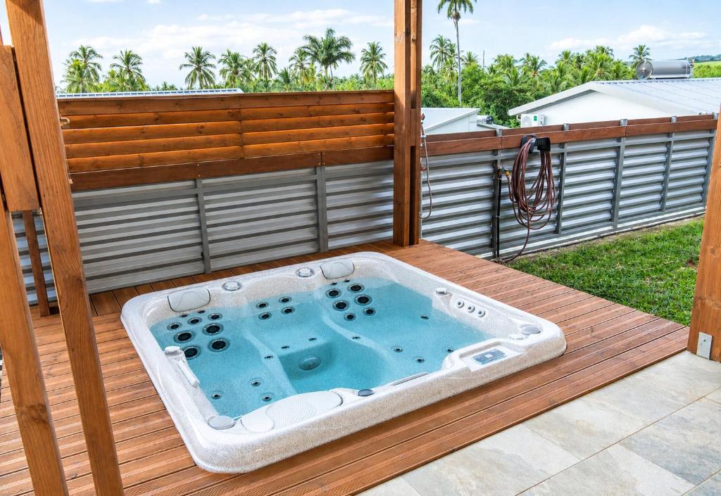 a jacuzzi tub on a deck at Le Cocon d'Ava - Bungalows & Spa in Saint-Paul