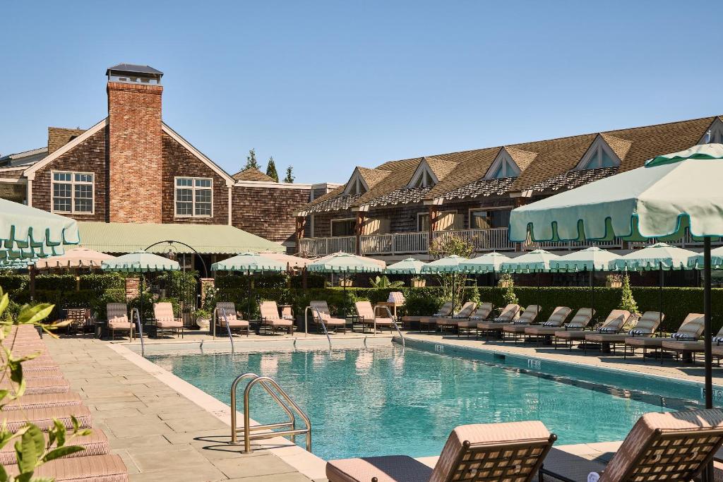 a large swimming pool with chairs and a building at Faraway Sag Harbor in Sag Harbor
