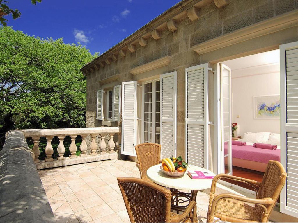 un patio con tavolo e sedie sul balcone. di Exclusive Villa with private pool huge fenced property near Dubrovnik a Čilipi