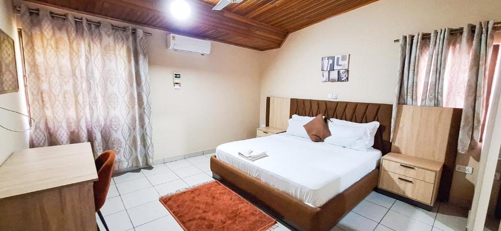 a bedroom with a bed and a table and a desk at First Choice Hotel in Accra