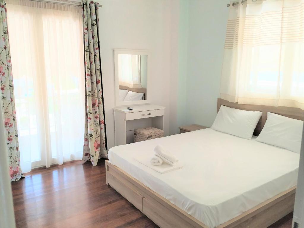 a bedroom with a white bed and a mirror at Ioannis Foteinos Studios in Lygia