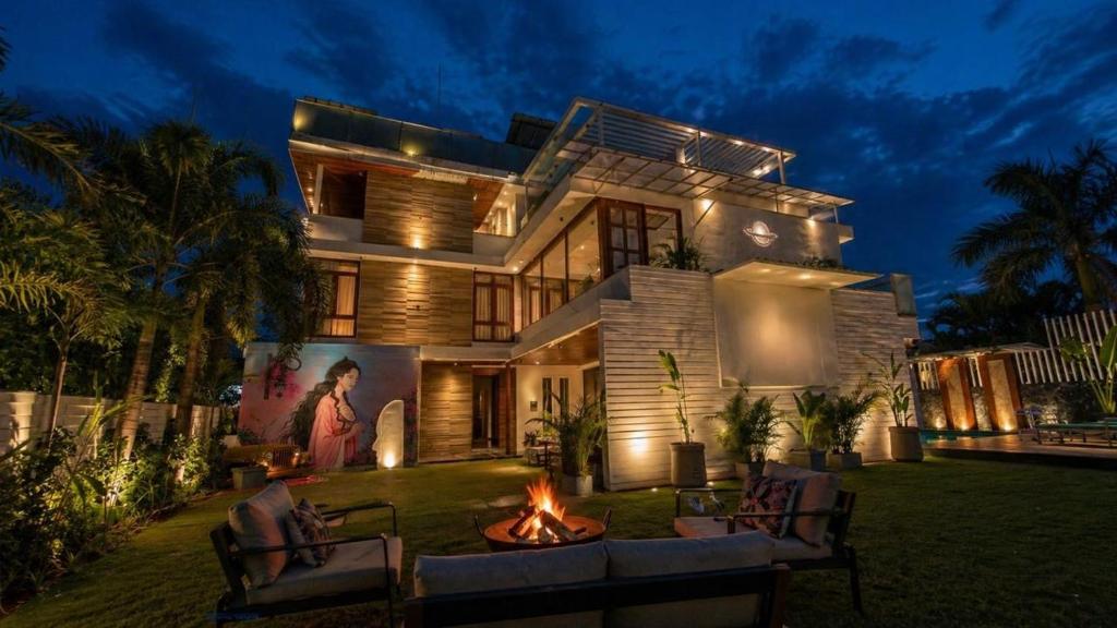 a house with a fire pit in the yard at night at Nova Bliss Villa in Nashik