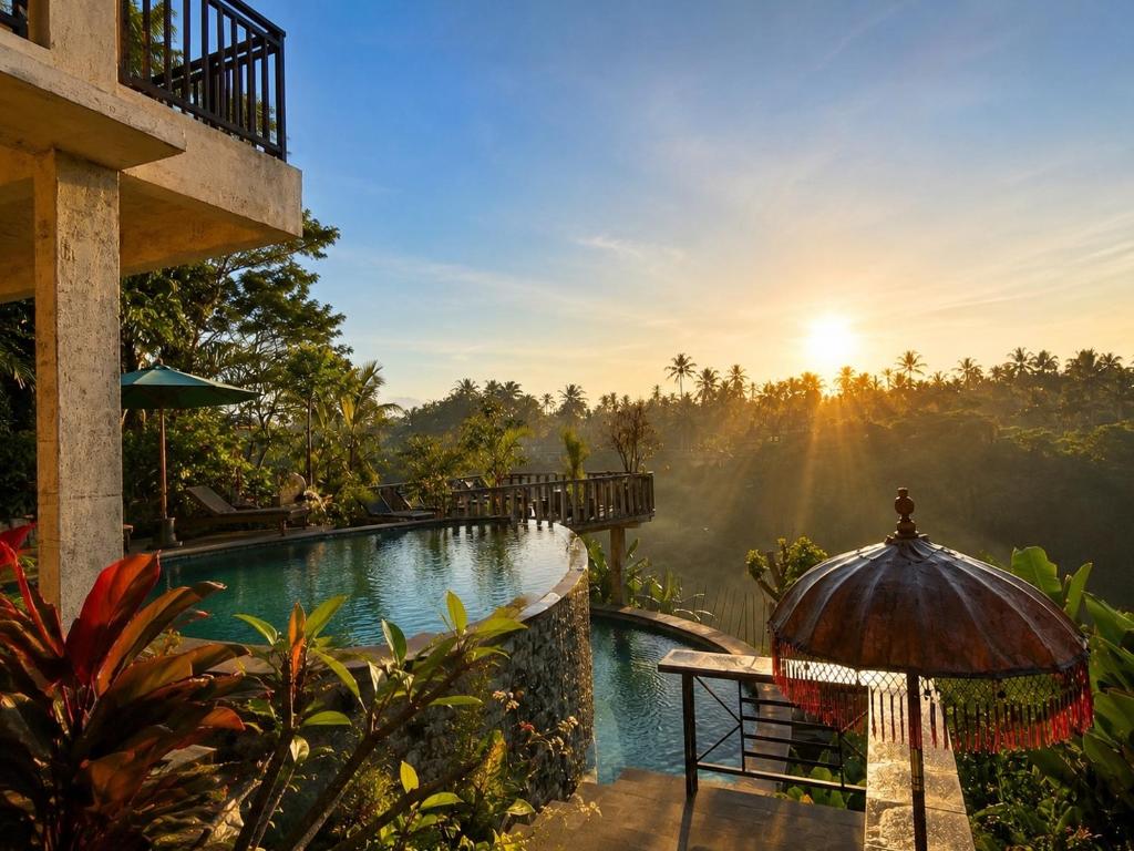 a view of a pool at a resort with the sun setting at D'Nanda mini hotel Ubud in Ubud