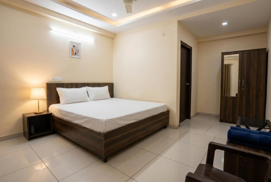 a bedroom with a bed and a lamp in it at Hotel Aarav Grand Chandigarh in Chandīgarh