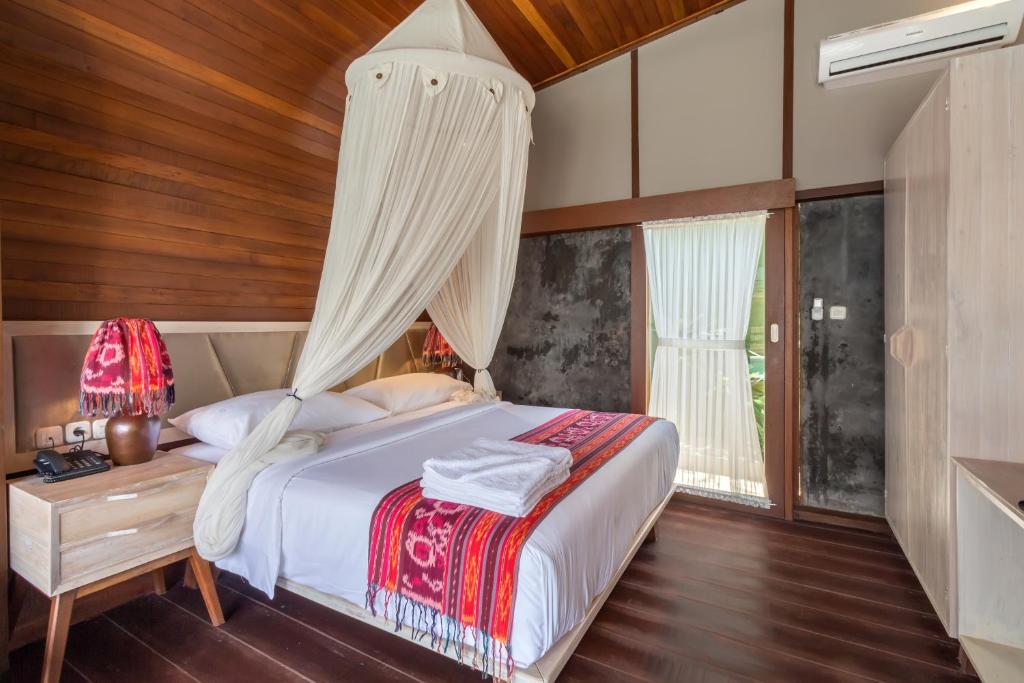 a bedroom with a bed with a canopy at Mola2 Resort Gili Air in Gili Islands