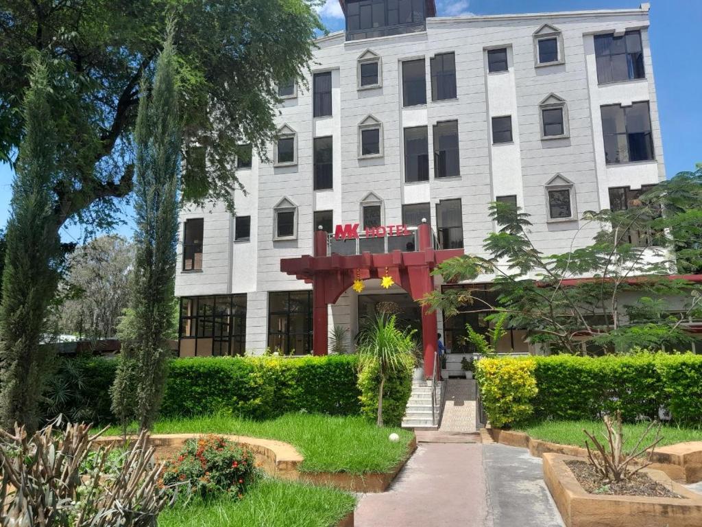 a large white building with a red structure at MK Hotel Hawassa in Āwasa