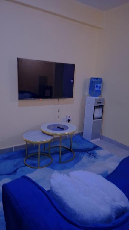 a living room with a table and a tv at BREE'S EXECUTIVE STAYs in Kakamega