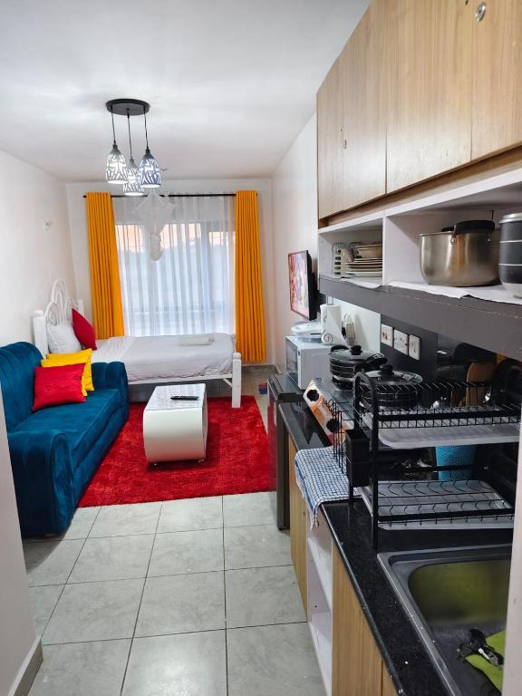 a kitchen and living room with a couch and a bed at GCurtway Homes Tsavo Superior Studios in Nairobi