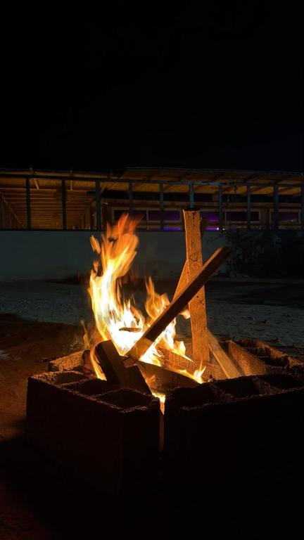 Nachts brennt ein Feuer in einer Feuerstelle. in der Unterkunft Aska camp in Oulad Akkou