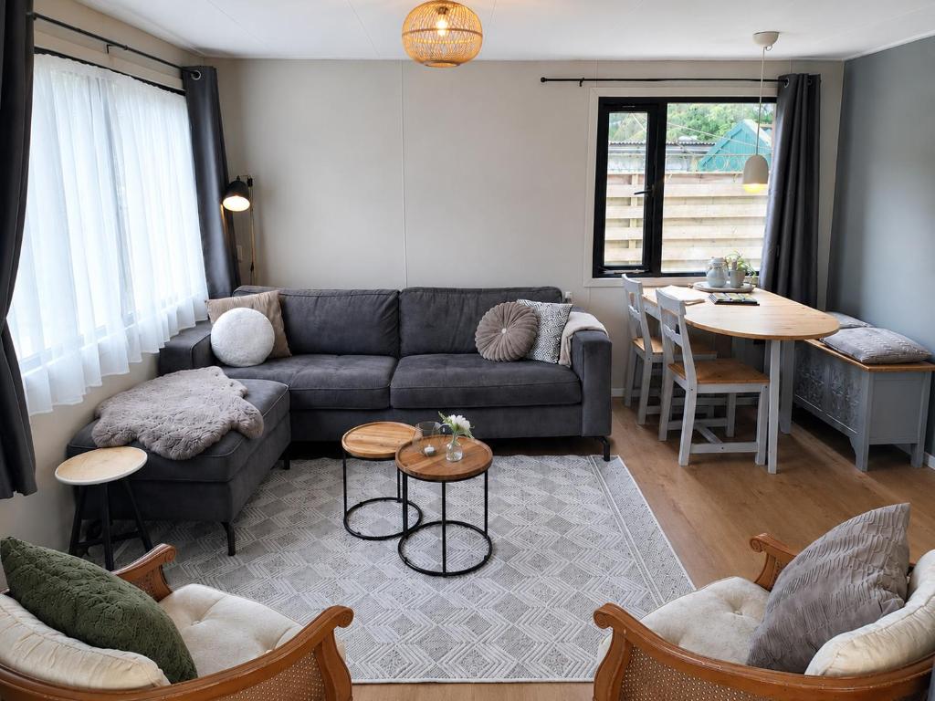 a living room with a couch and a table at Sfeervol Chalet - Gelegen In bosrijkgebied van Drenthe - Rust en Natuur in Eext