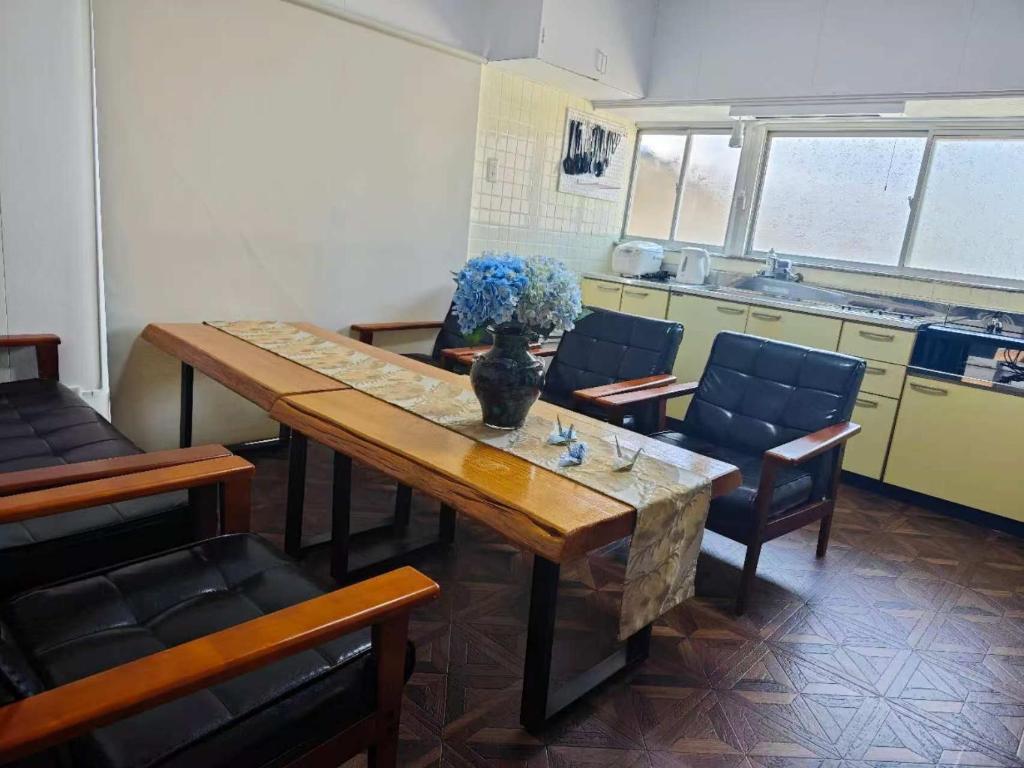 a room with a table and chairs and a kitchen at インジホテル下関 in Shimonoseki