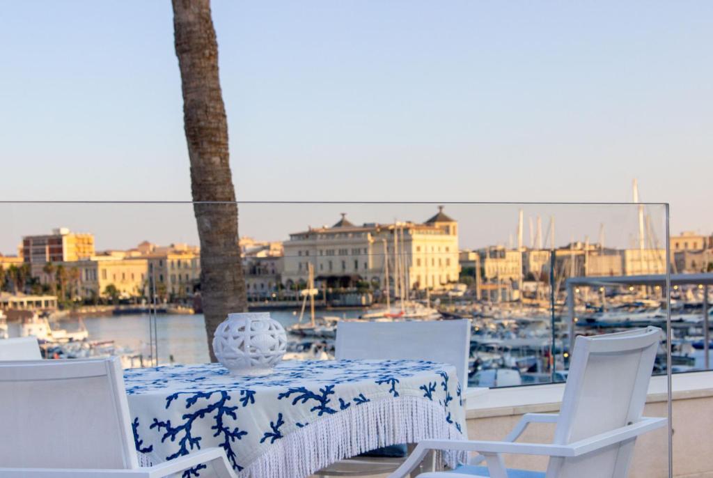 a table and chairs with a view of a harbor at Marina Homes Sea View Ortigia in Syracuse