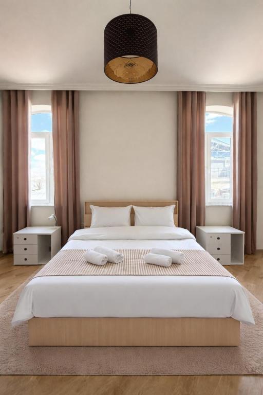 a bedroom with a large bed with two towels on it at Miassine Boutique Hotel in Gyumri