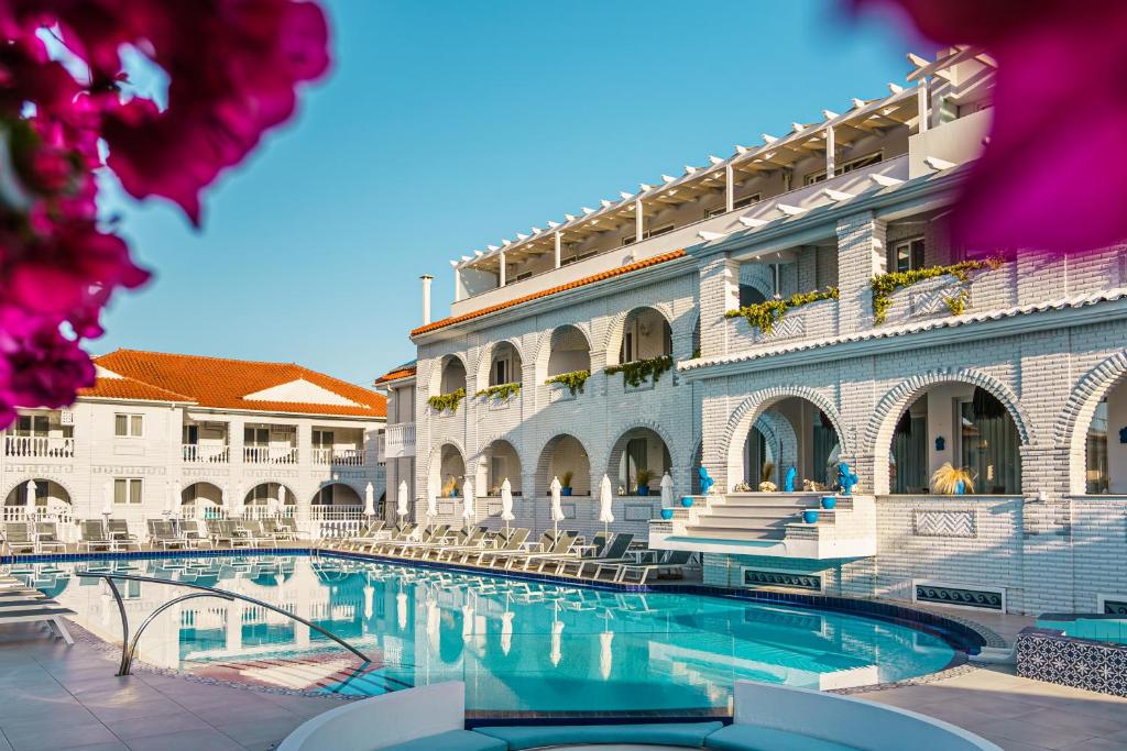 a hotel with a swimming pool in front of a building at Meandros Boutique & Spa Hotel - Adults Only in Kalamaki