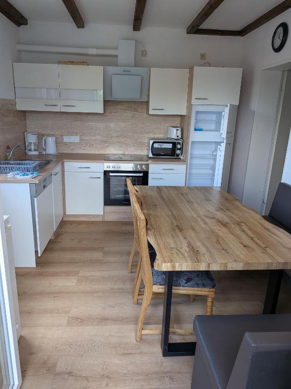 a kitchen with a wooden table and white cabinets at Adlerhorst in Bruchhausen-Vilsen