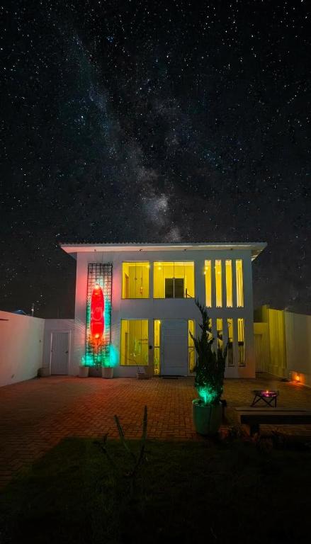 a house lit up at night with green and red lights at Recanto Luigi in Brotas