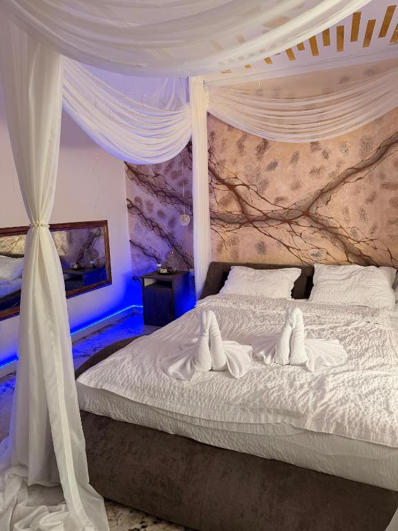 a bedroom with a white bed with a canopy at Guesthouse Bârlogul Balaurului in Afumaţi