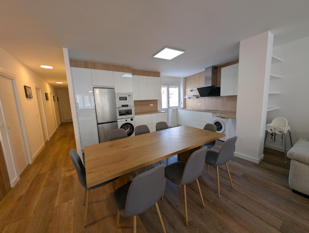 a kitchen and dining room with a wooden table and chairs at Alojamientos Bahia de Santoña 4 in Santoña