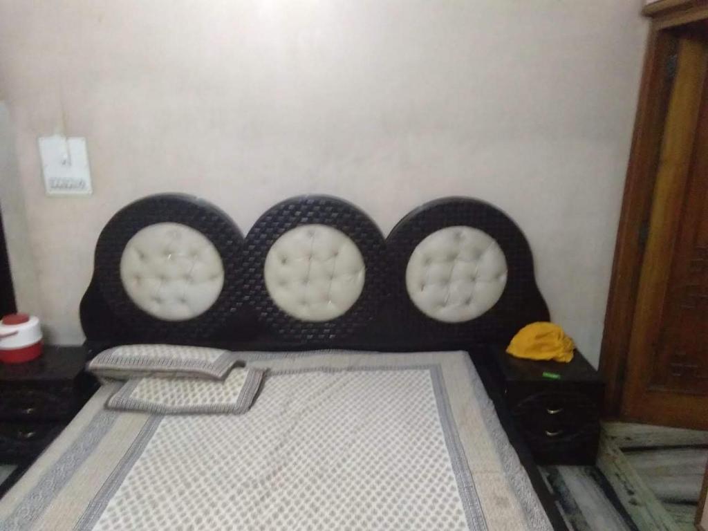 a bed with a head board with three circles on it at Atlas blue hotel in Bathinda