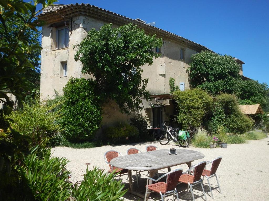 a table and chairs in front of a building at Ma Maison De Loin - Luberon in Apt