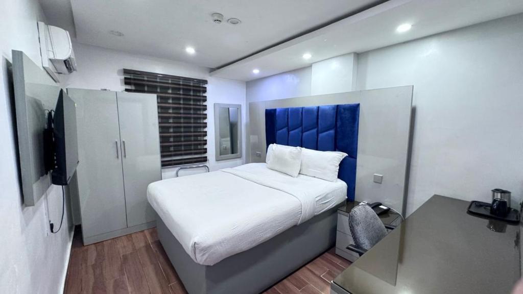 a bedroom with a large bed with a blue headboard at Novatel Radisson Lekki in Lekki
