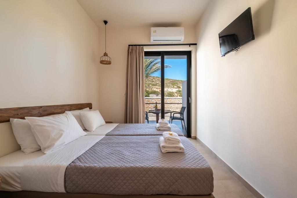 a bedroom with a bed with towels on it at Prasonisi Lighthouse Asimenis in Prasonisi