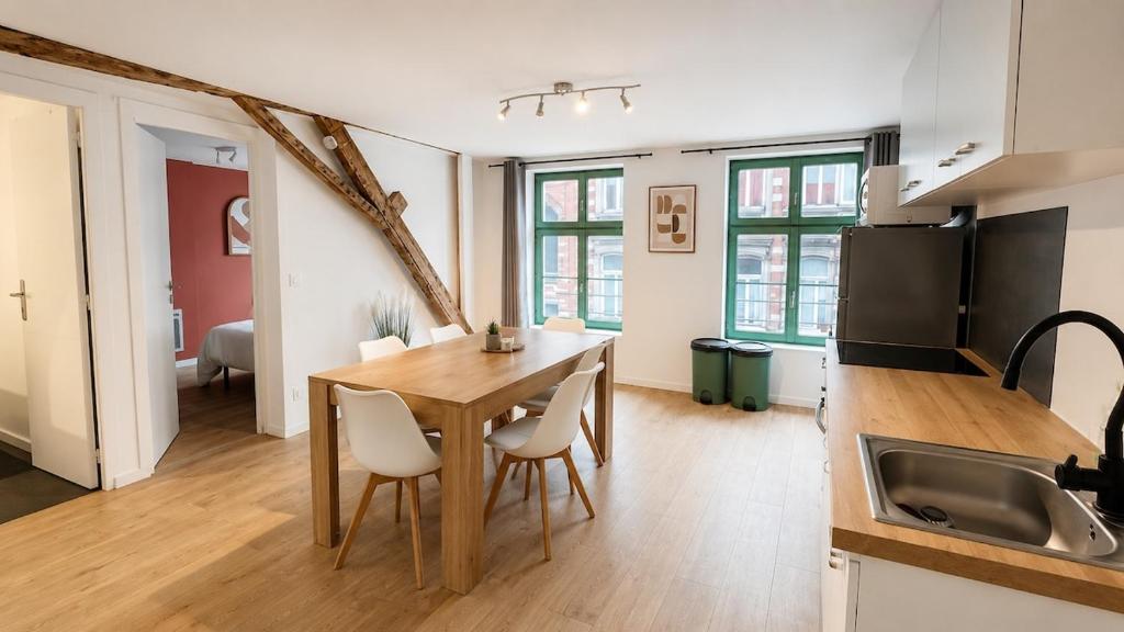 a kitchen and dining room with a table and chairs at Le Clos Delobel in Tourcoing