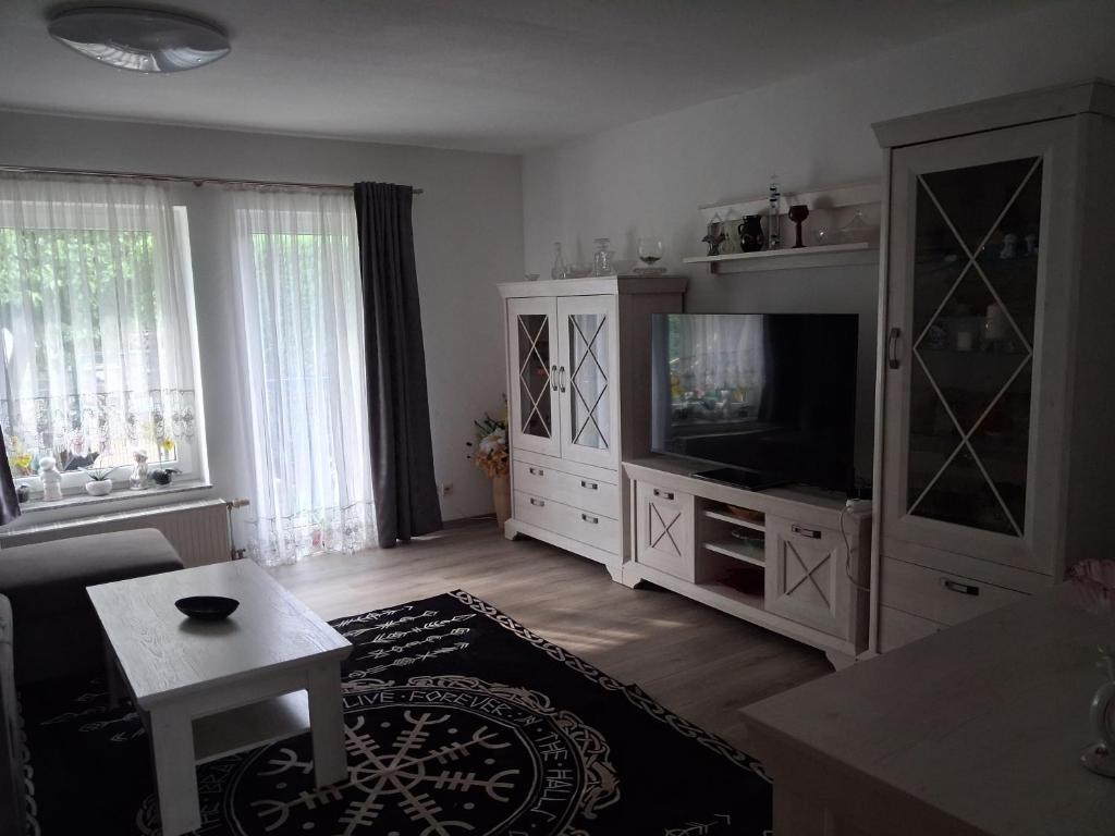 a living room with a tv and a entertainment center at Ferienwohnung Silvia in Steinhagen